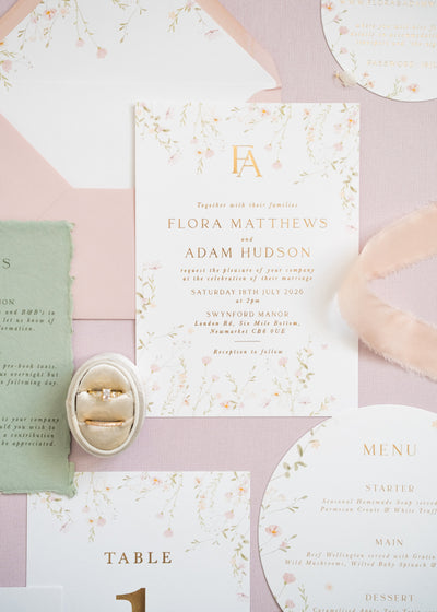 A flat lay of pink floral wedding stationery