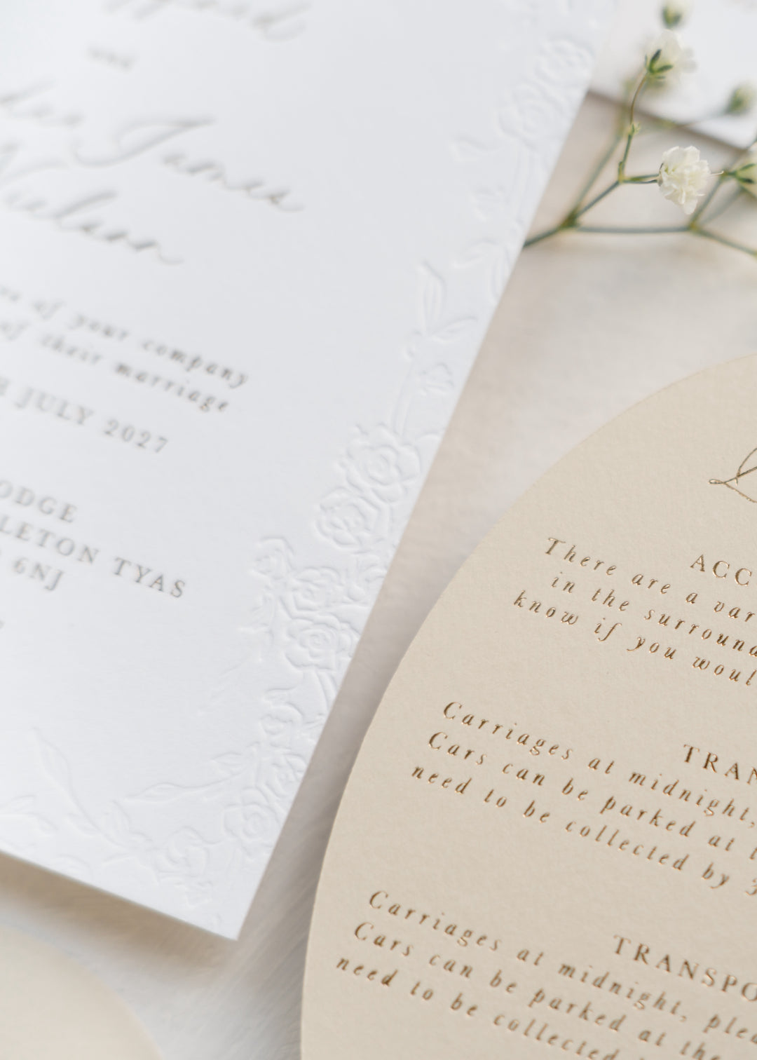 Close-up of elegant wedding invitations with text and floral elements.