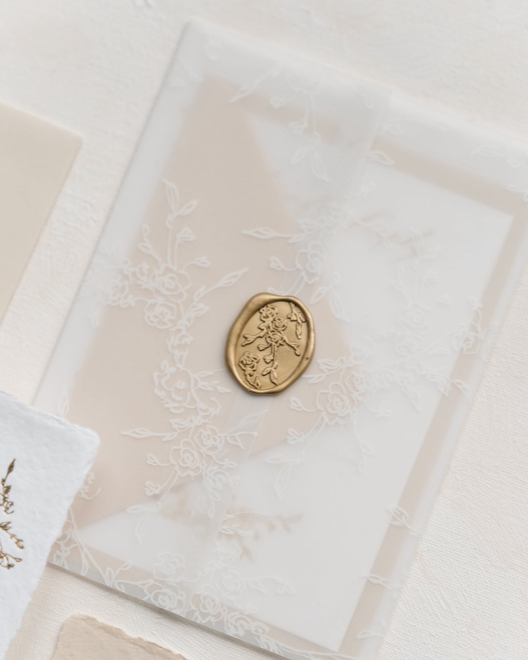 Decorative vellum wrap with a gold seal on a light background