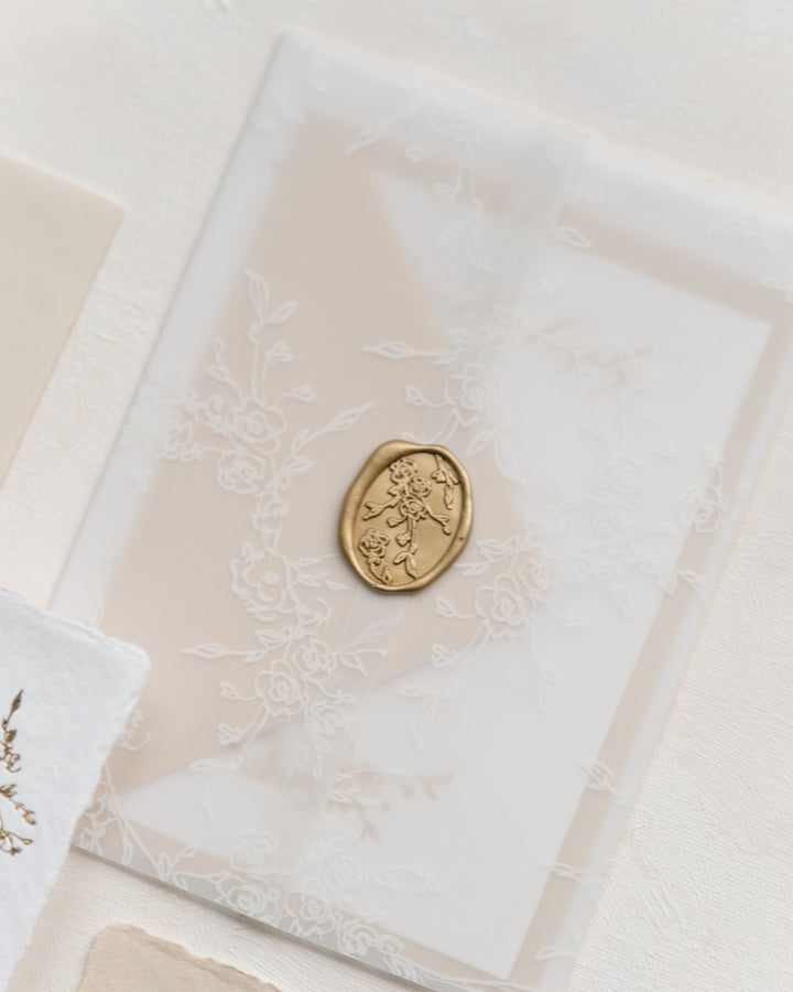 Decorative vellum wrap with a gold seal on a light background