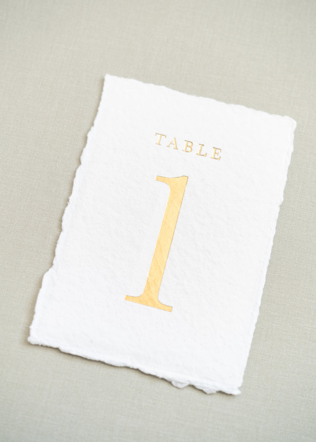 white handmade paper and gold foil table number 1