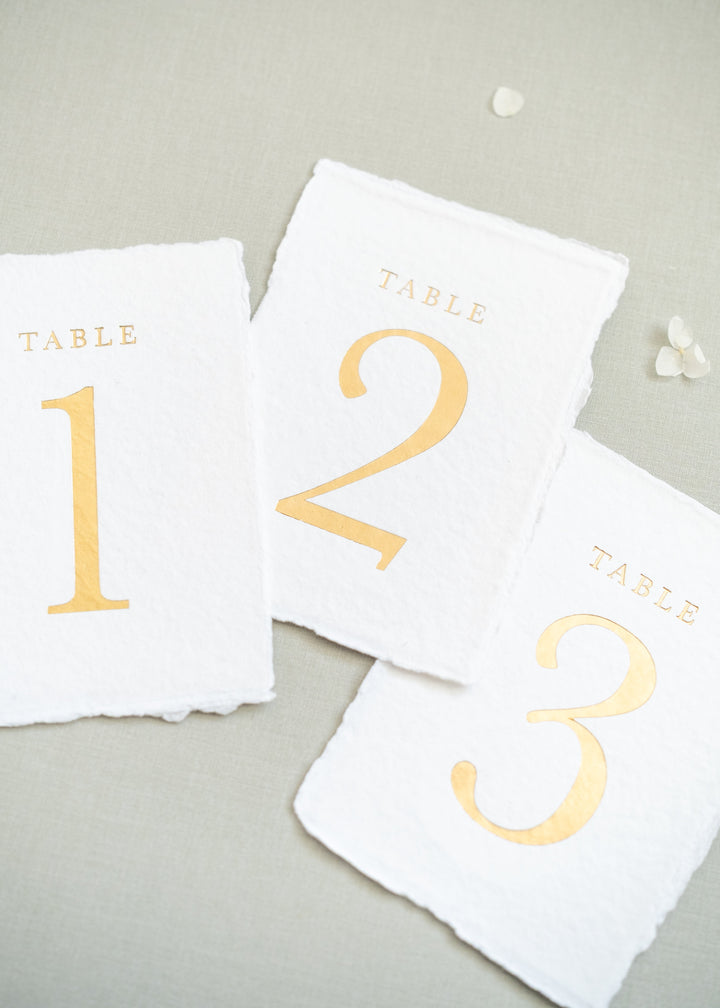 white handmade paper and gold foil table numbers 1, 2 and 3